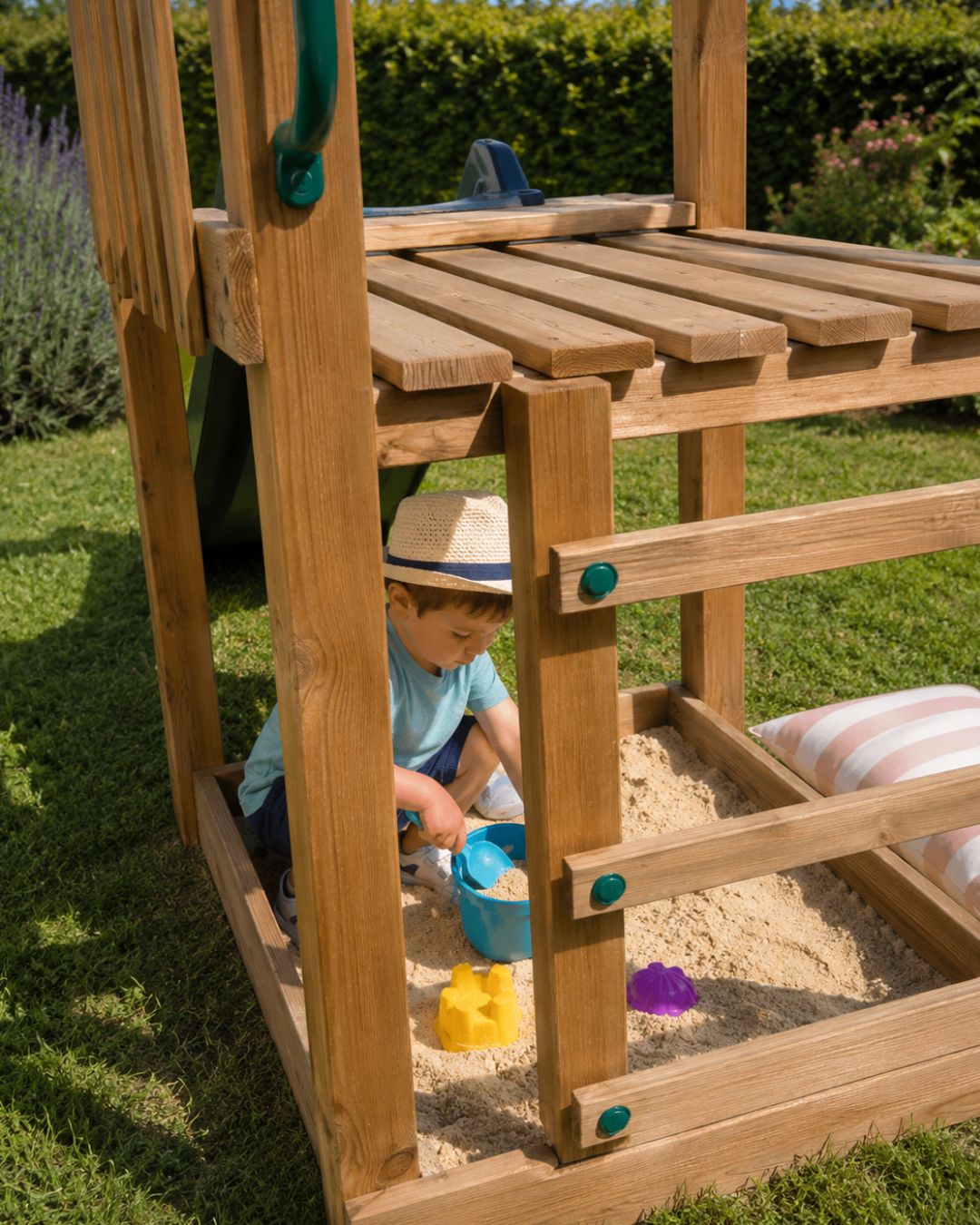 Niños jugando a la sombra en un arenero bajo plataforma